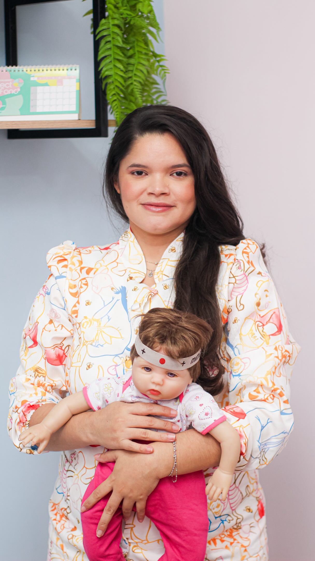 Gleiciane segura uma boneca durante uma demonstração no consultório